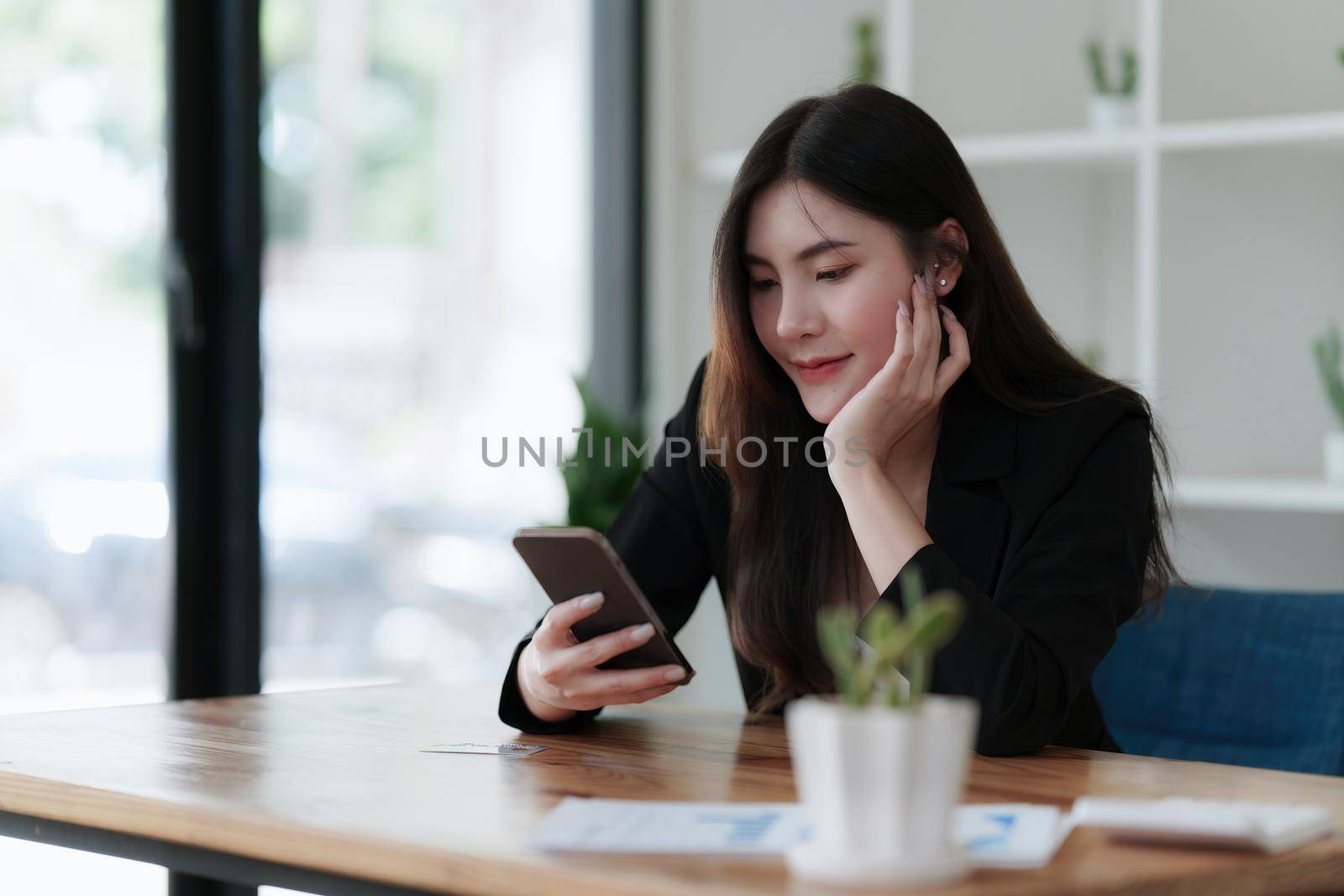 Young asian business woman smiling and chatting on mobile phone.