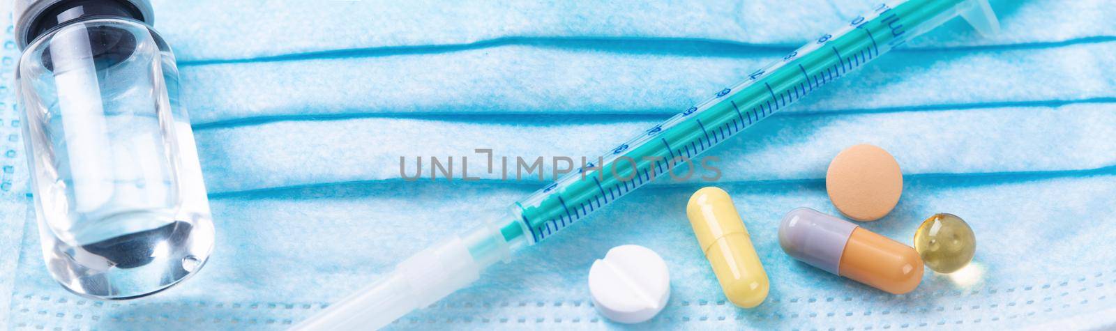 Medical syringe with a needle and pills. Corona virus vaccine. by Taut