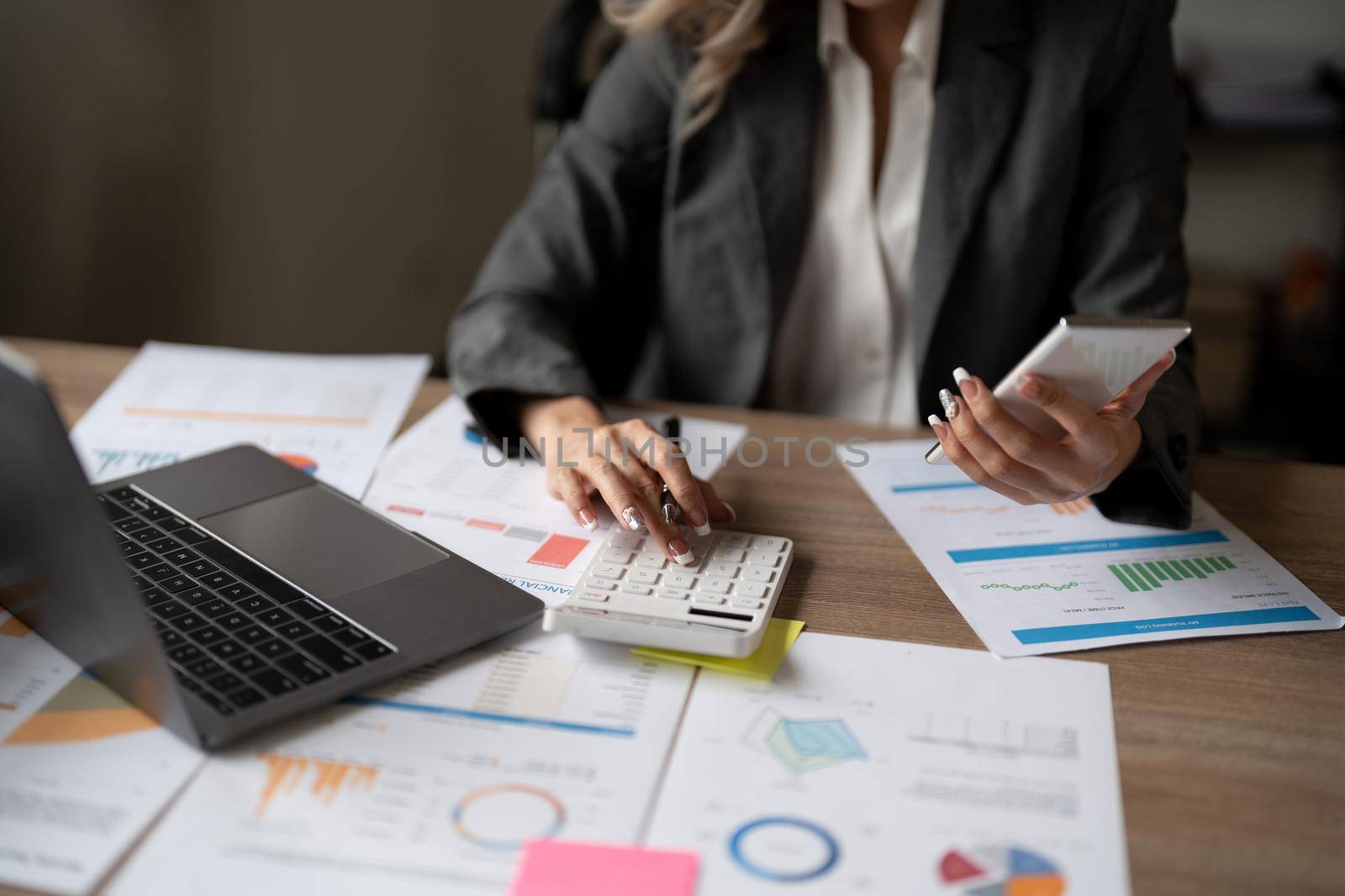 Accountant woman working on desk using calculator for calculate finance report in office.