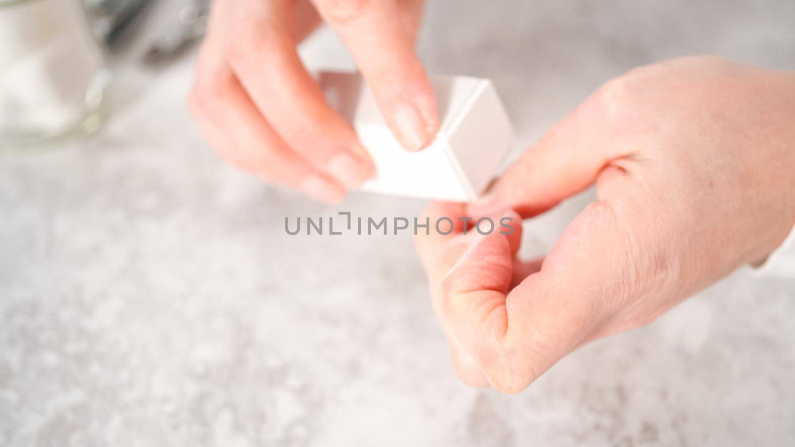 Woman finishing her manicure at home with simple manicure tools. Buffering nails with a nail buffer block.