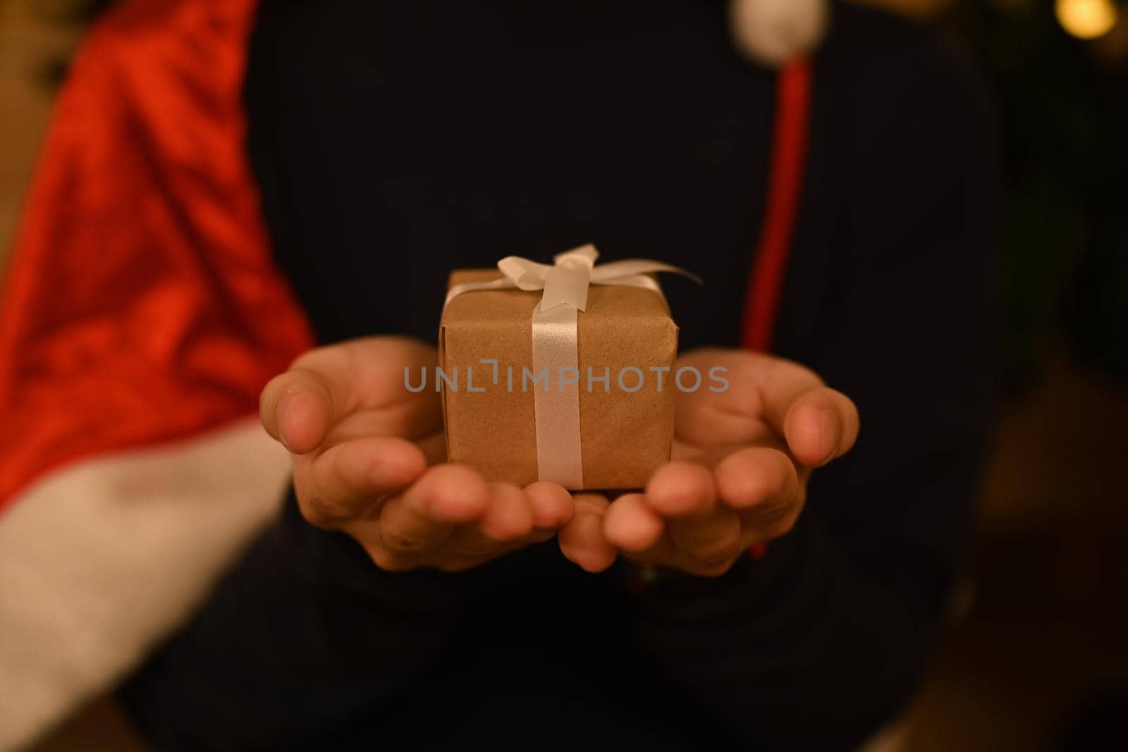 Close up view of man holding Christmas Gift in hands. New year and Christmas concept.