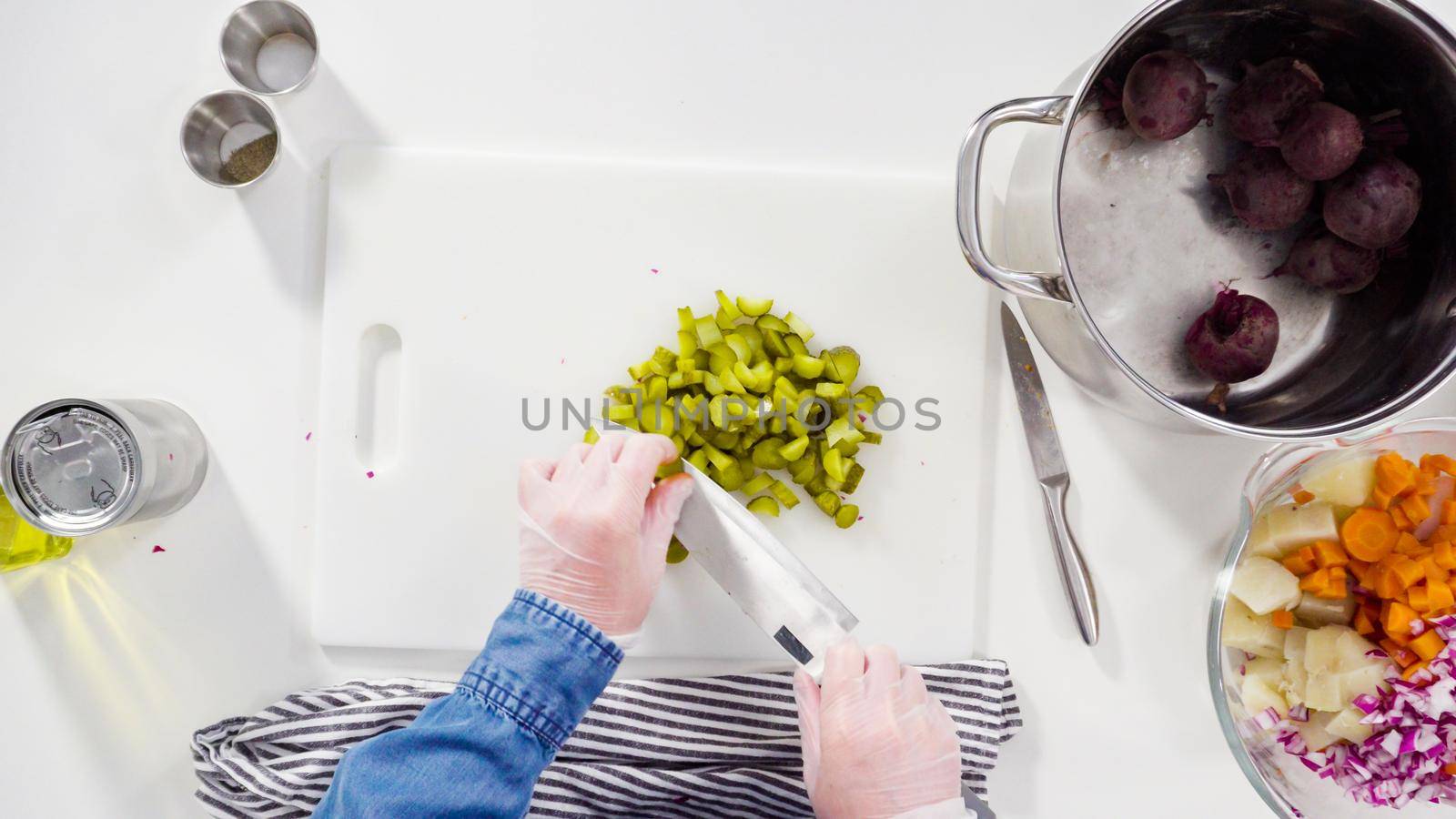 Flat lay. Step by step. Cutting cookies vegetables on a white cutting board for vinaigrette salad.