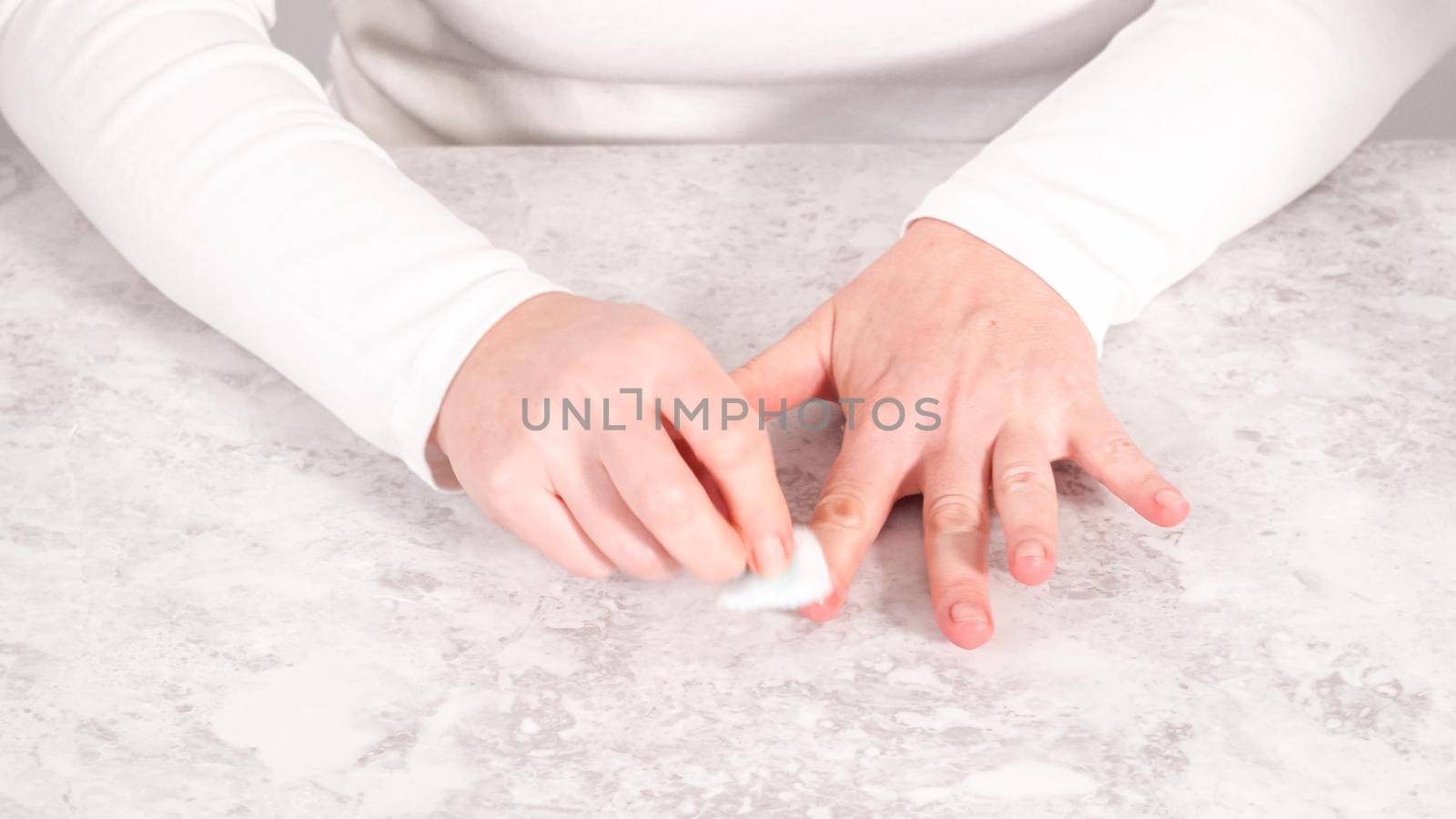 Woman finishing her manicure at home with simple manicure tools. Removing old nail polish from the nails.