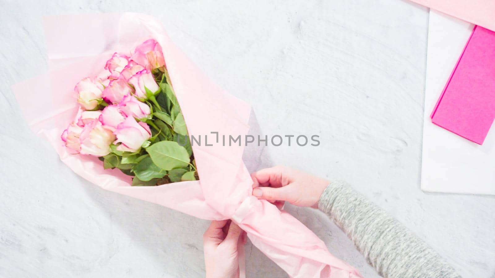 Flat lay. Step by step. Florist arranging a bouquet from pink roses.