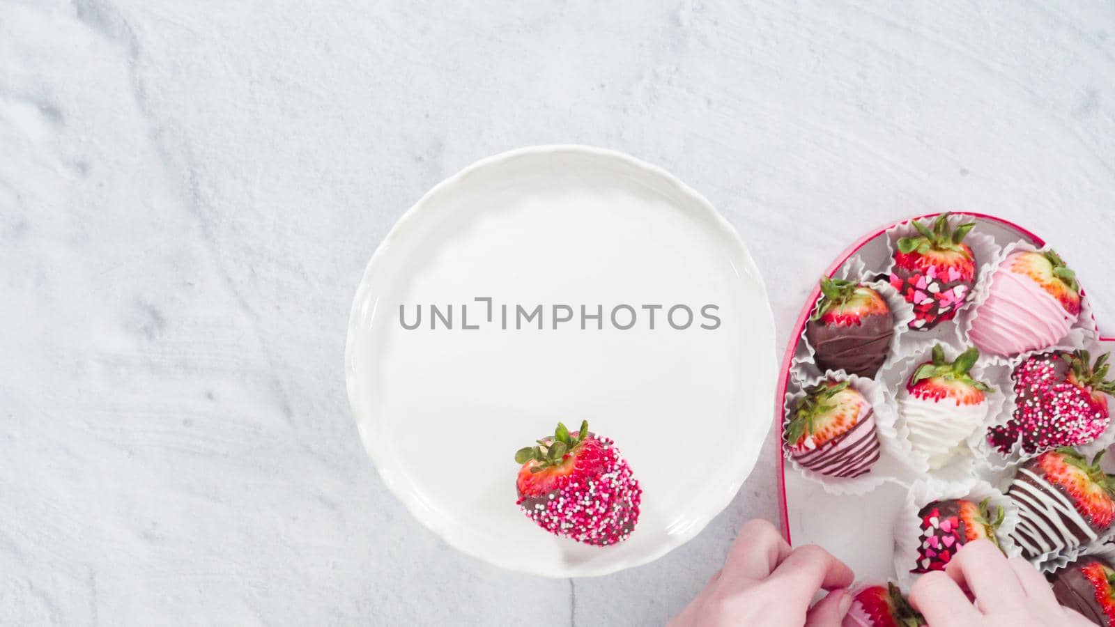 Flat lay. Step by step. Placing chocolate dipped strawberries on a white cake stand.