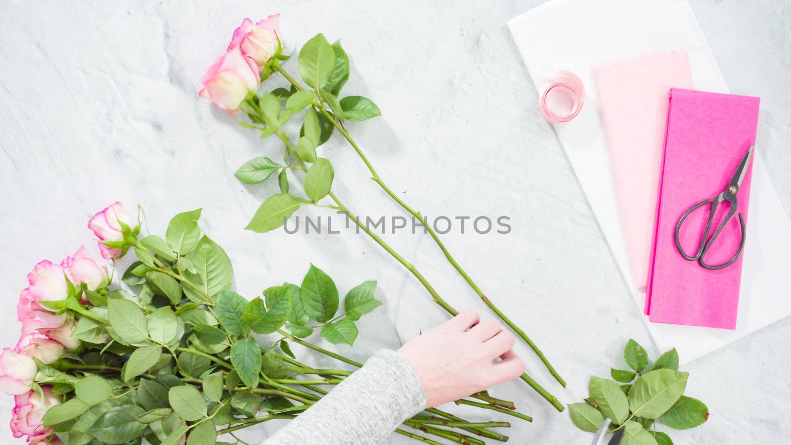 Flat lay. Step by step. Florist arranging a bouquet from pink roses.