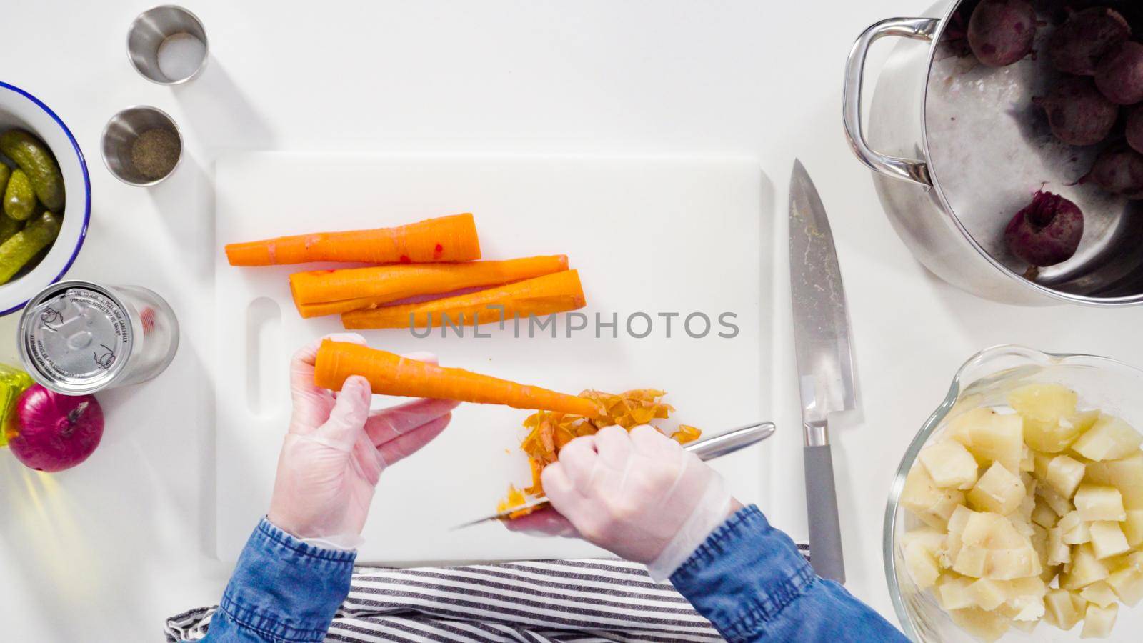 Flat lay. Step by step. Cutting cookies vegetables on a white cutting board for vinaigrette salad.