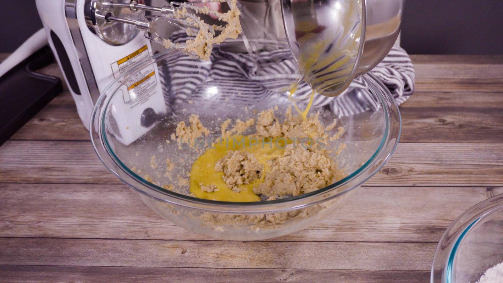 Step by step. Mixing ingredients to bake oatmeal raising cookies in a glass mixing bowl.