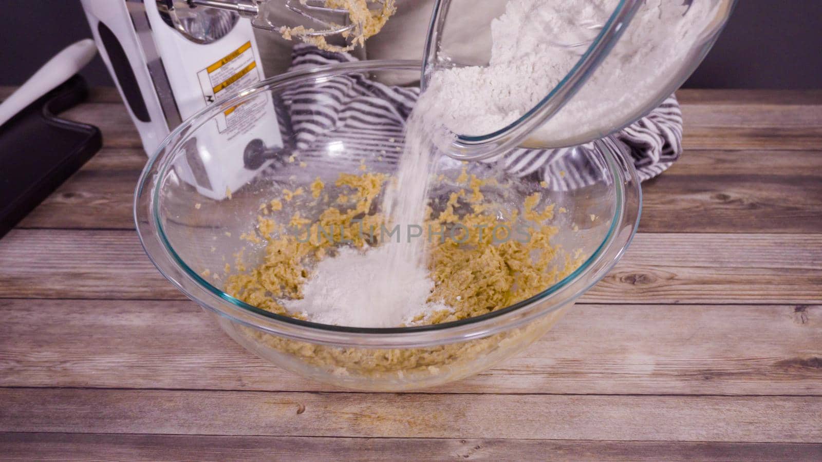 Step by step. Mixing ingredients to bake oatmeal raising cookies in a glass mixing bowl.