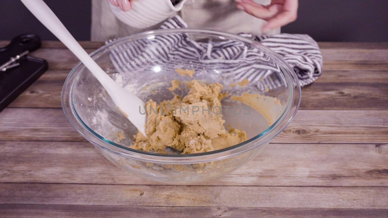 Step by step. Mixing ingredients to bake oatmeal raising cookies in a glass mixing bowl.