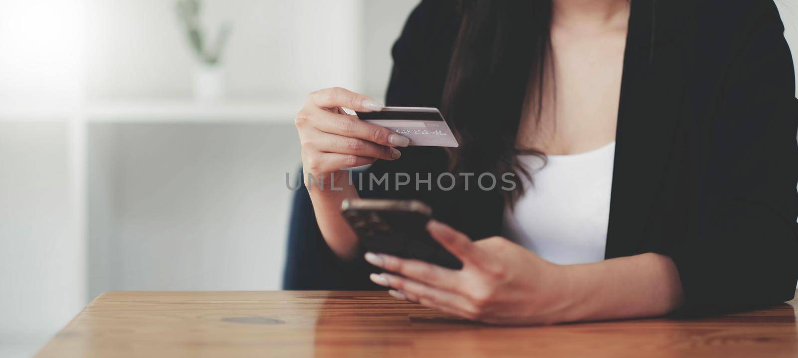 Woman hands holding smartphone shopping online with credit card. Online Payment. Online shopping concept. by wichayada