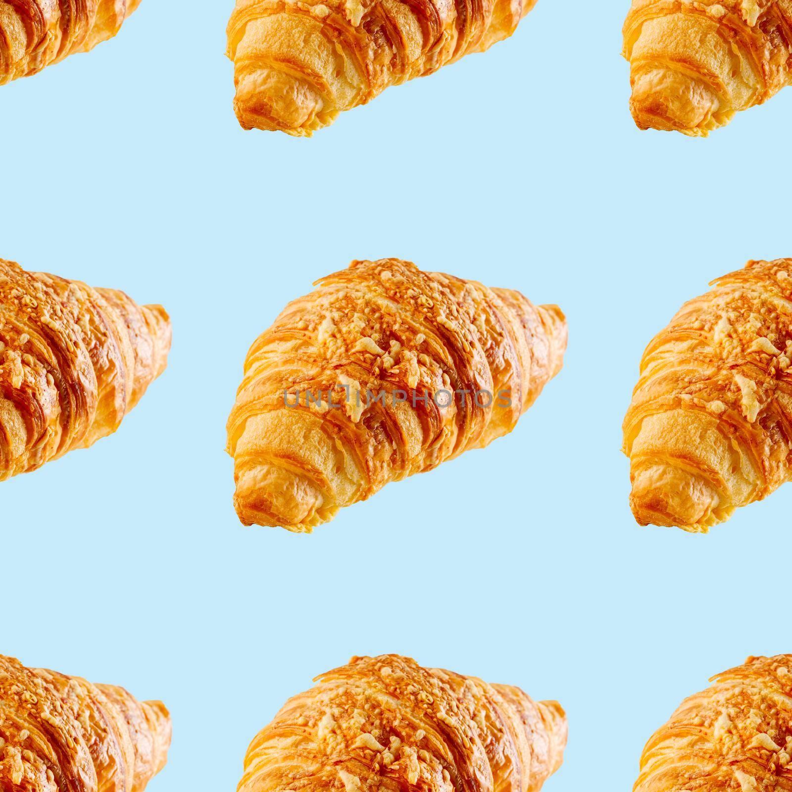 seamless pattern made from Fresh croissant isolated on blue background. Bakery pattern with baked croissant with cheese.