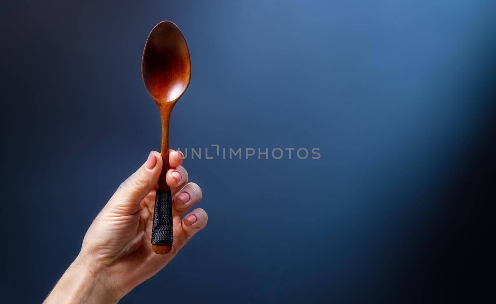 Hand holding wooden spoon by GekaSkr