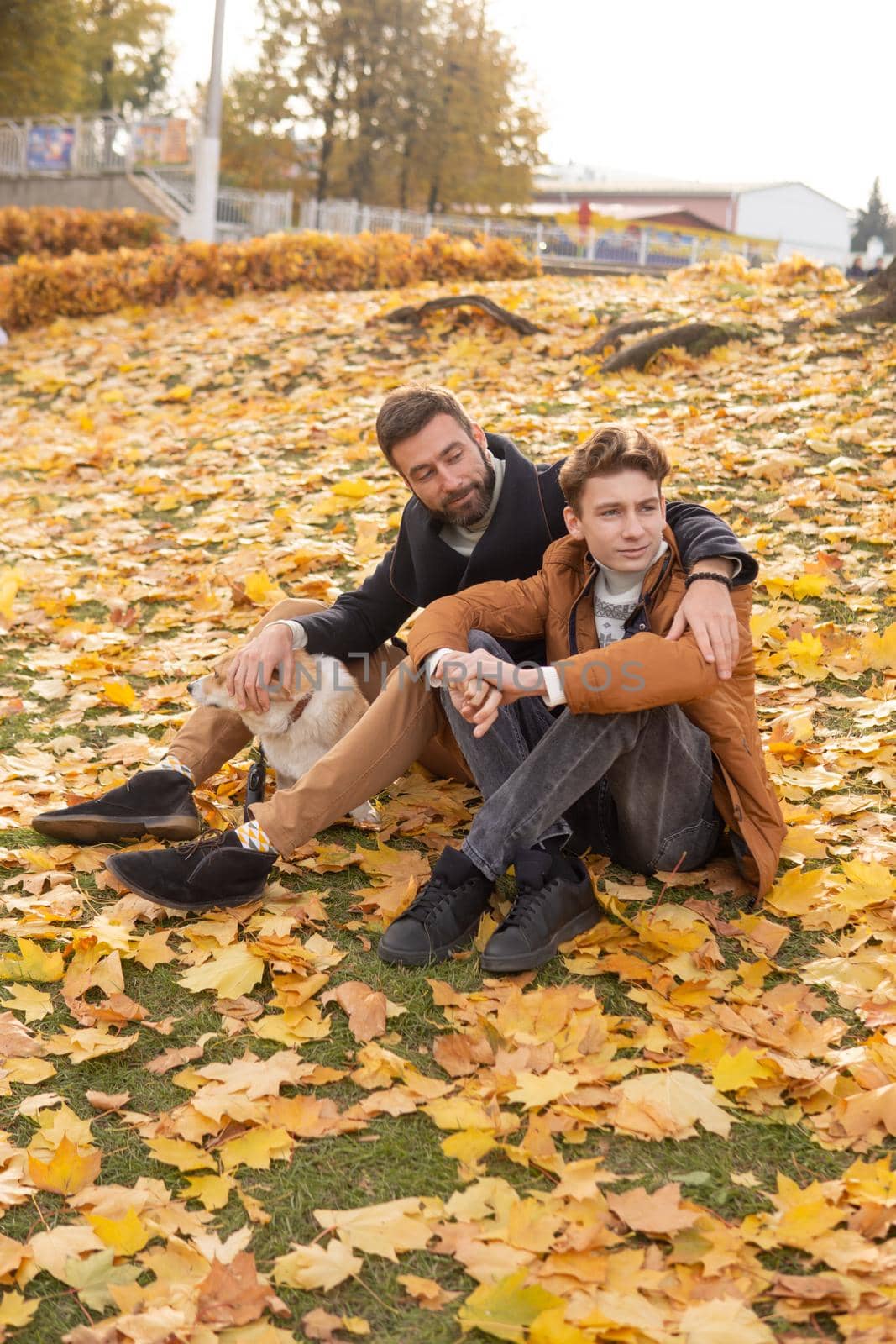 Father and son with a pet on a walk in the autumn park by Annu1tochka