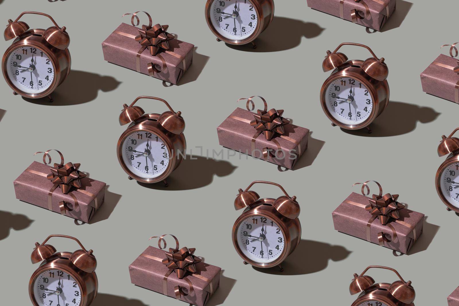 Brown gift box template with bow and alarm clock on gray background. Festive minimalistic concept.