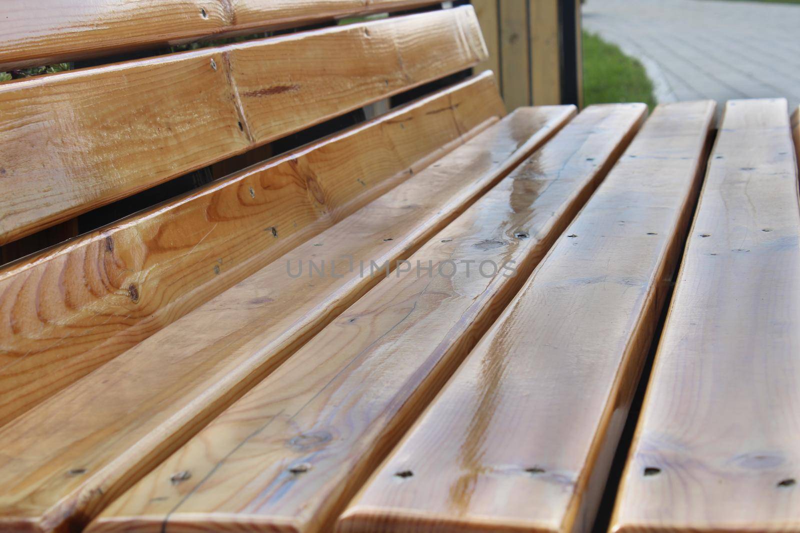 Light wooden bench in the city park close-up. Urban architecture.