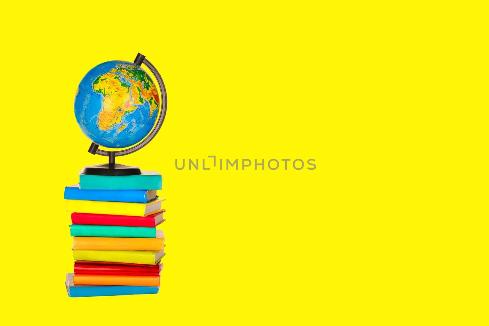 Books, a globe on a yellow background. Back to school concept Space for text