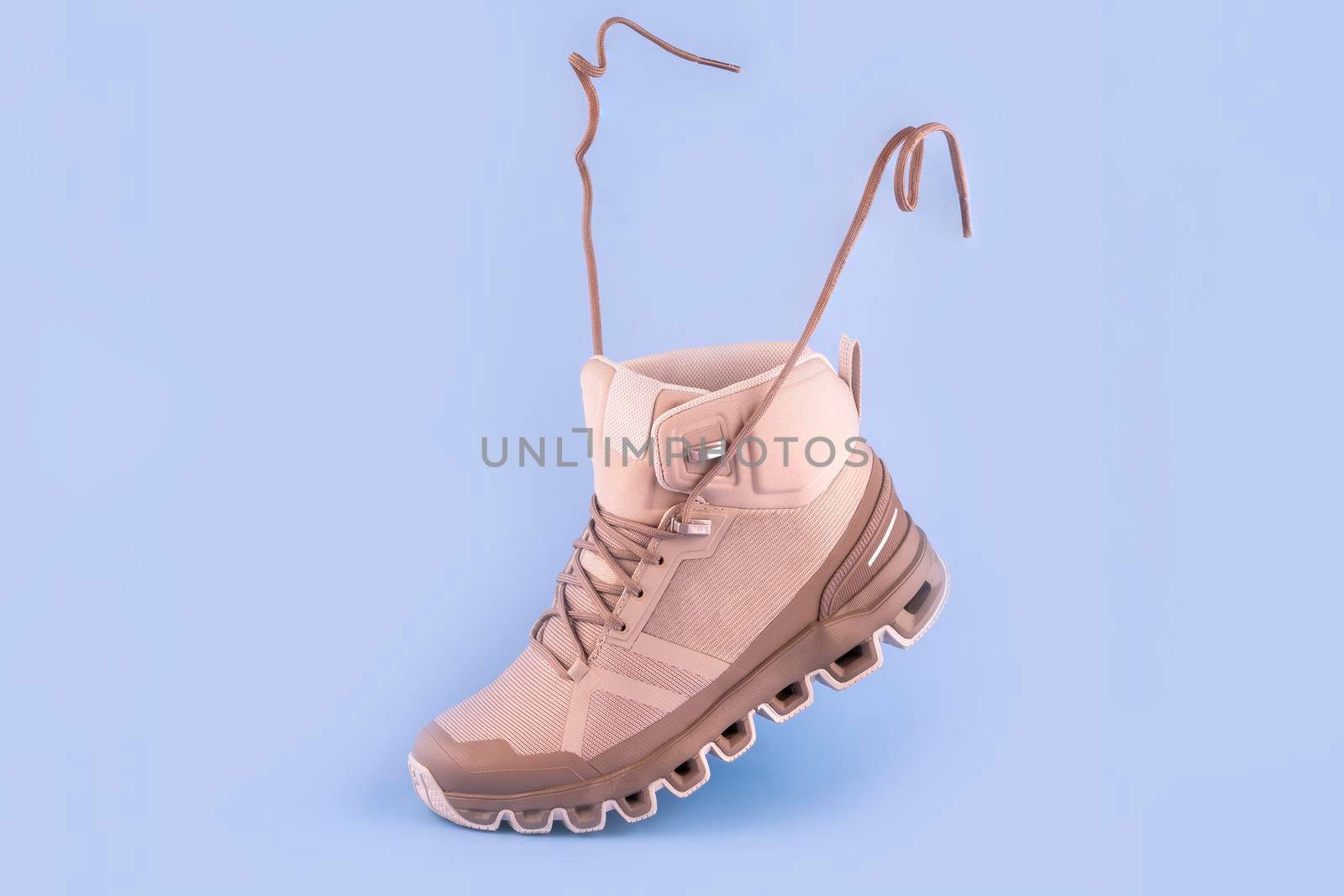 woman cream hiking boot,isolate on a blue background by Iryna_Melnyk