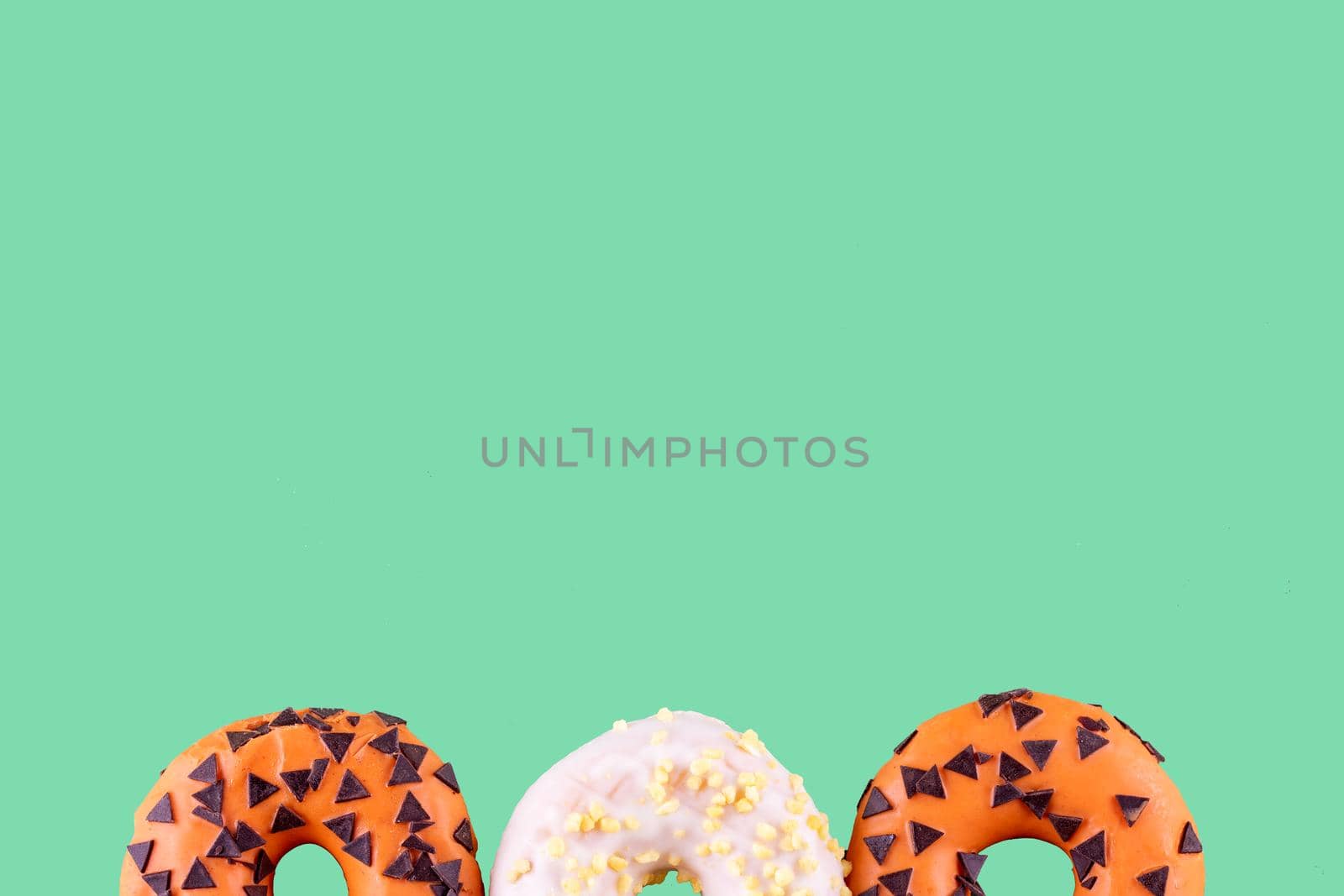 two orange donuts and one white on an blue background Space for text high-quality photos for calendar and cards