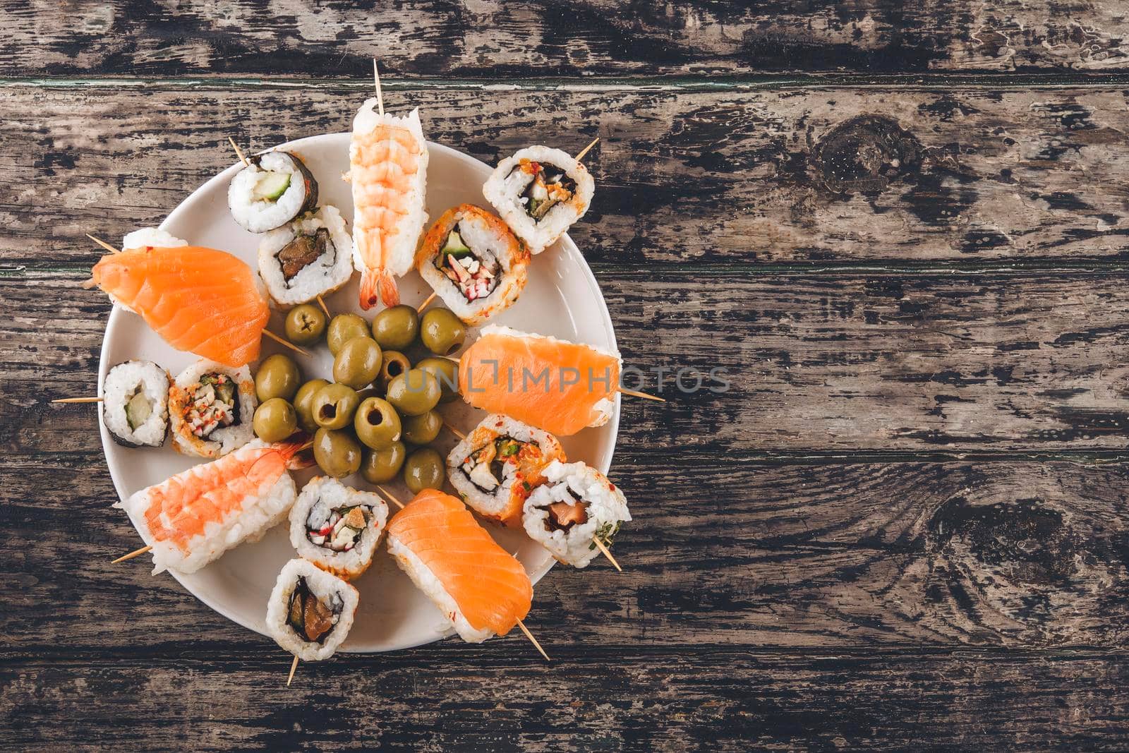 a set of sushi and soy sauce on a white plate in the form of ready-to-eat canapes on a wooden background by Iryna_Melnyk