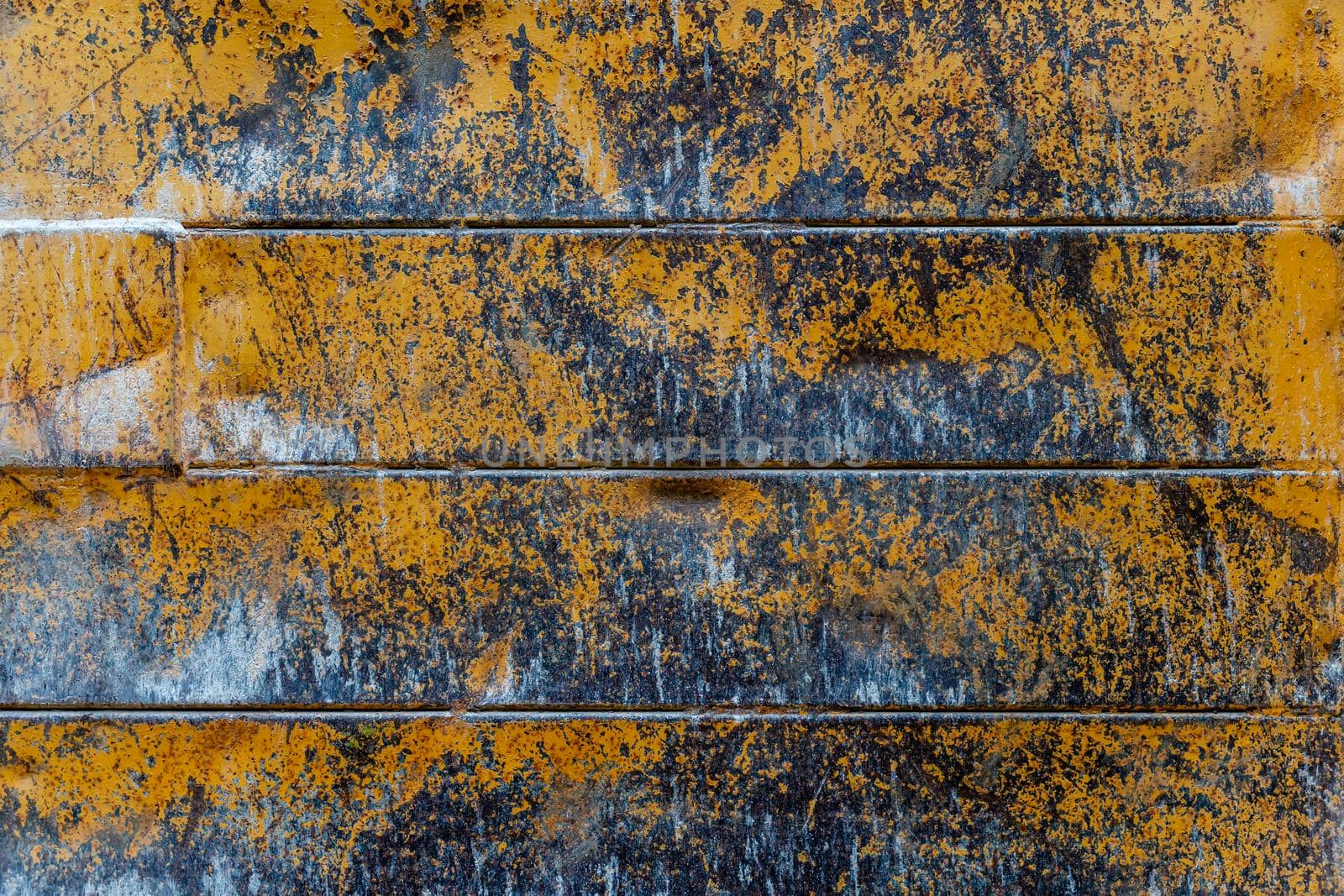Grunge rusty metal texture background with patches of old yellow paint