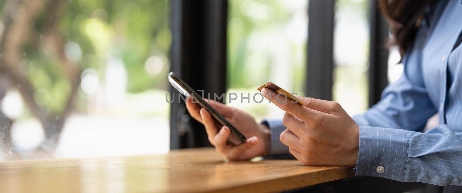 Close up woman hands with smartphone and credit card for online payment. by nateemee