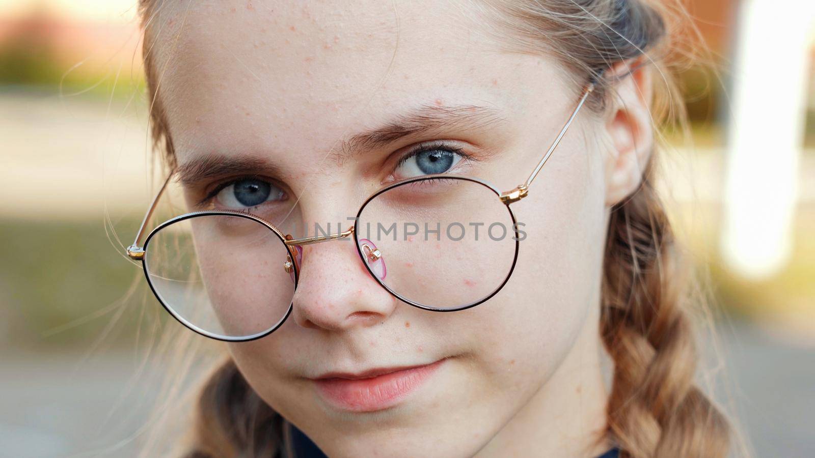 A teenage girl wearing glasses. Close-up of her face