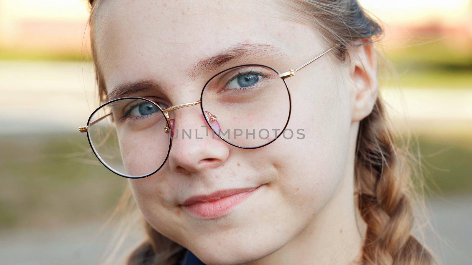 A teenage girl wearing glasses. Close-up of her face