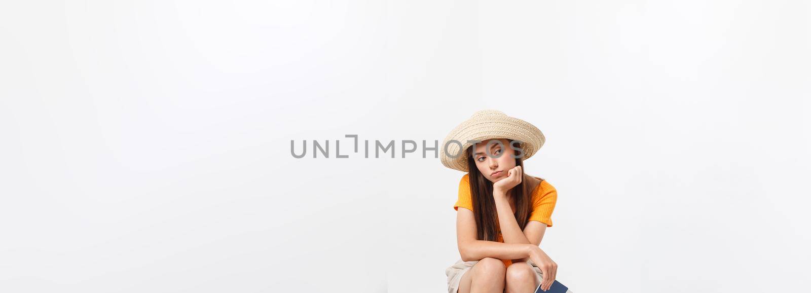 Lifestyle and travel Concept: Young beautiful caucasian woman is sitting on suitecase and waiting for her flight.Isolated over white background.