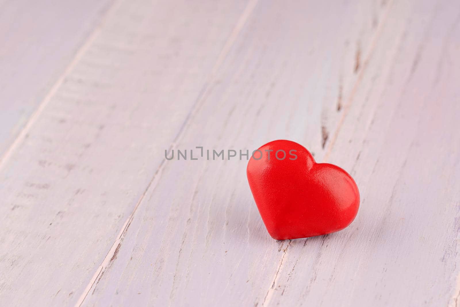 Close up of red hearts on wooden table against defocused lights. St. Valentine's Day background by Iryna_Melnyk