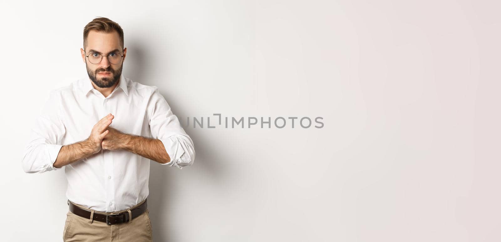 Angry man crack knuckles, want to punch someone, standing mad against white background.