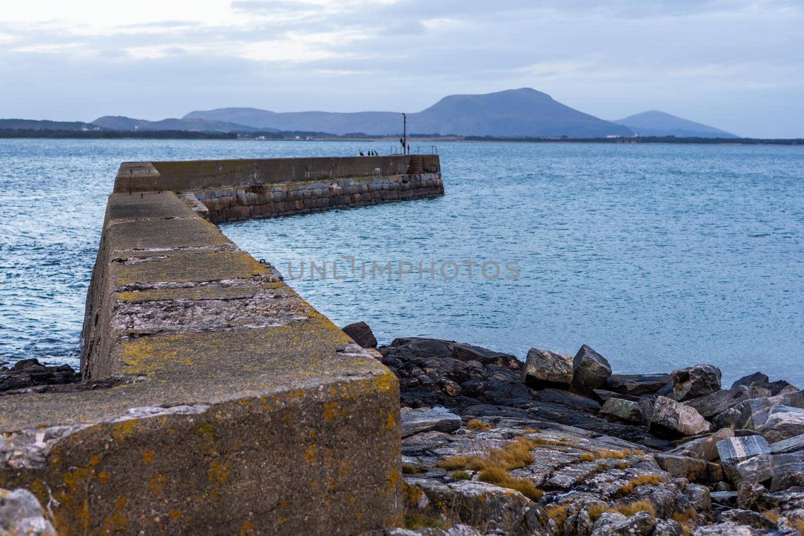 Beautiful image of a breakwater structure in the sea in Alesund, Norway; beach background by bildgigant