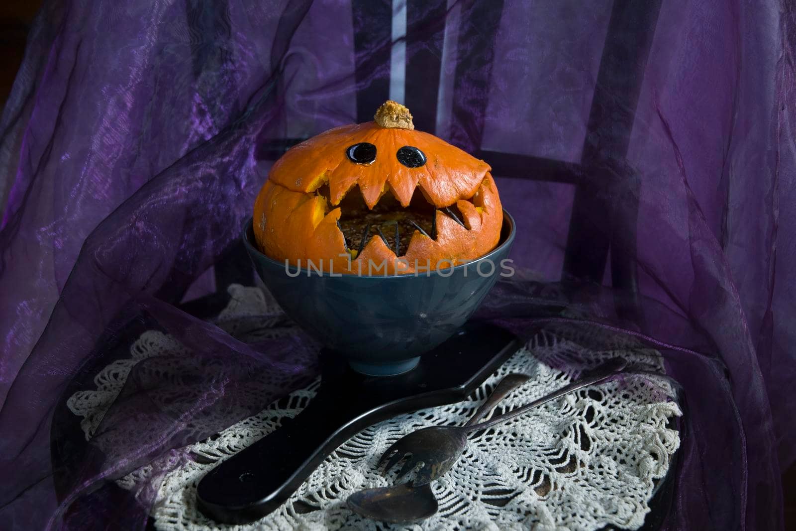 Halloween Pumpkin head, pumpkin with teeth and eyes, selective focus, vertical photo in a dark key. High quality photo