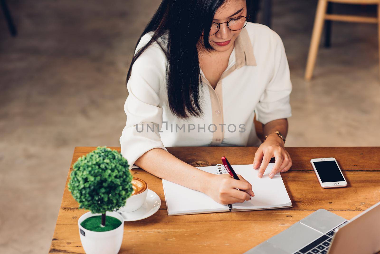 Business young women lifestyle freelance working using laptop computer and he write book note order while sitting outdoor modern loft cafe shop, Businesswoman making notes notepad planning schedule
