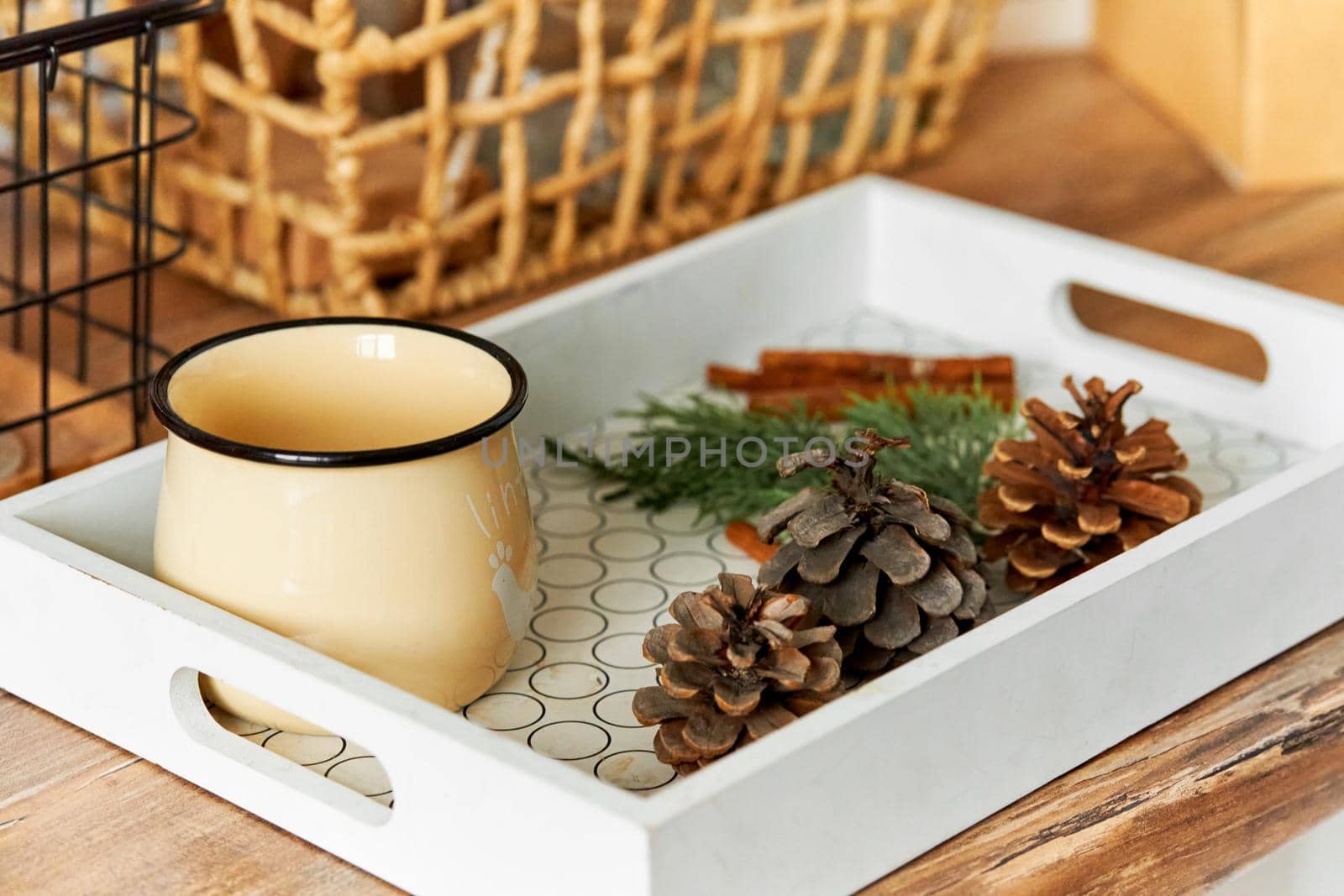 A tray with a jug of hot tea and pine cones. It will keep warm in cold autumn.