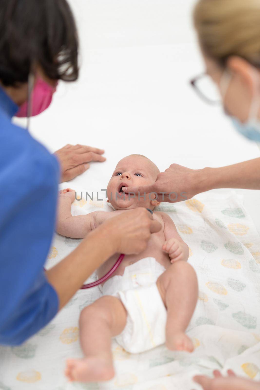 Baby lying on his back as his doctor examines him during a standard medical checkup.