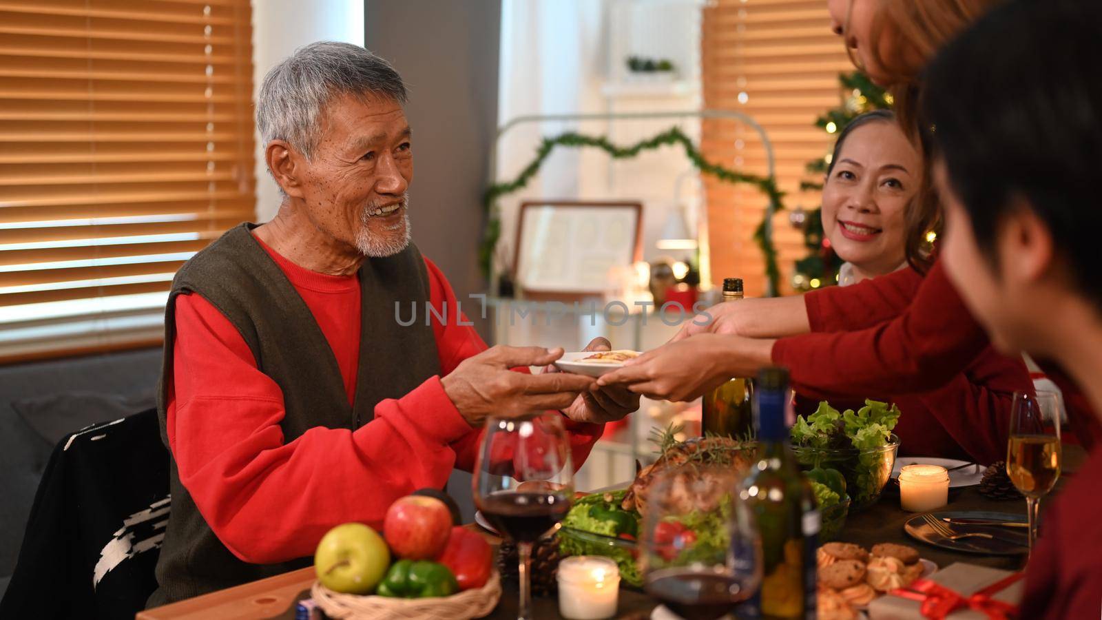Happy senior man having Thanksgiving dinner party with family. Celebration, holidays and Christmas concept by prathanchorruangsak