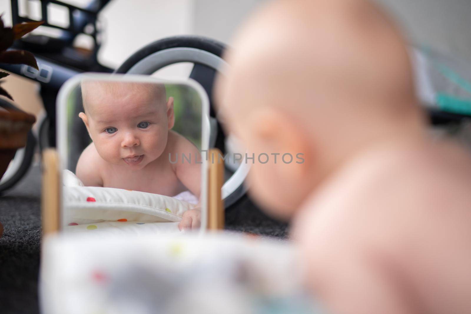 Beautiful shot of a cute baby boy looking at his reflection in the mirror.