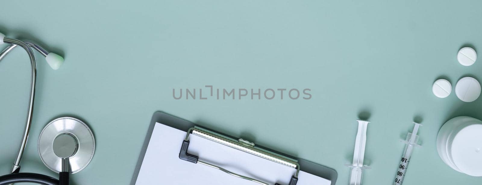 Banner with pills, stethoscope and tablet at doctor's workplace. Medical flat lat with copy space.