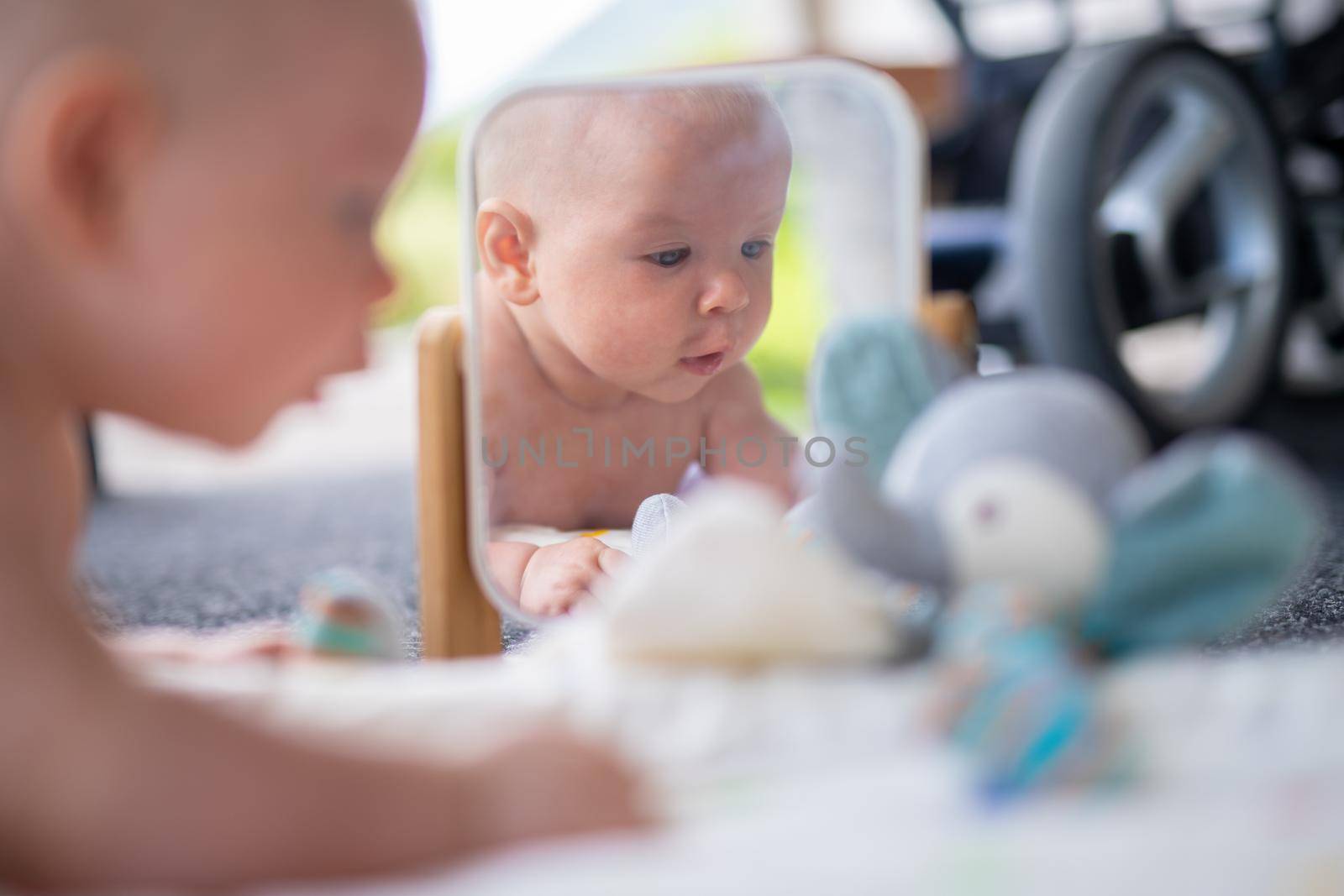 Beautiful shot of mirror reflectiona of cute baby boy playing with toys. by kasto