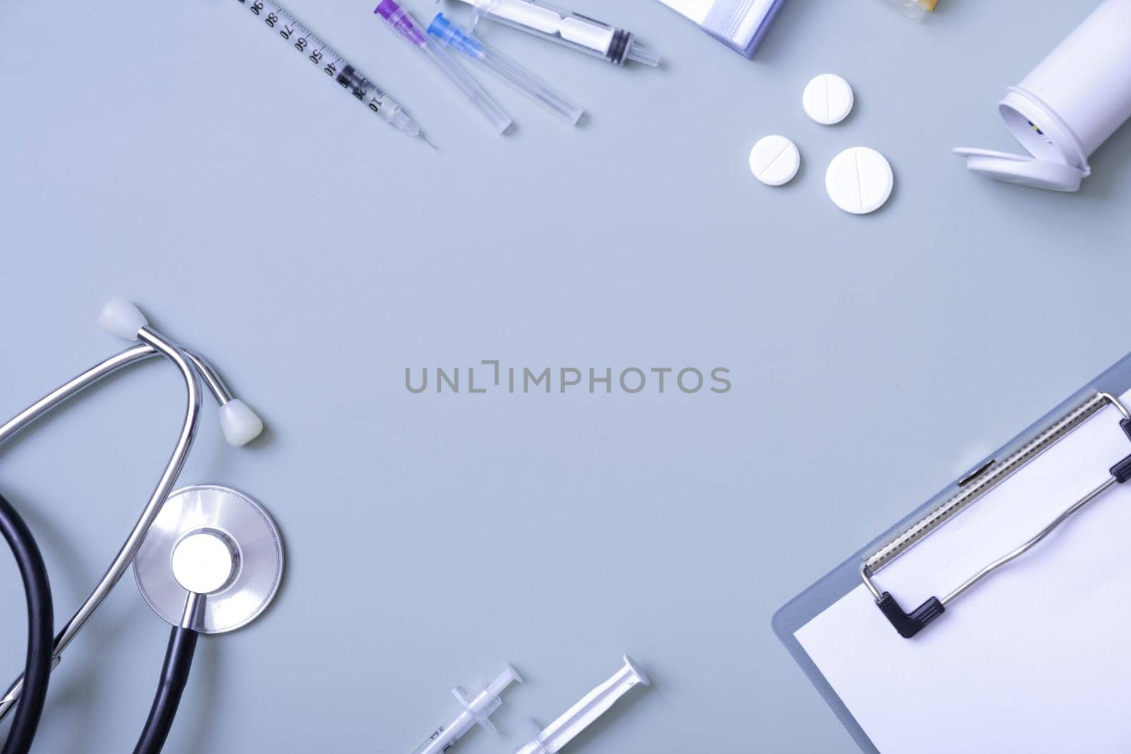 Medical stethoscope and pills on colored background with copy space. Top view of abstract medical background by ssvimaliss