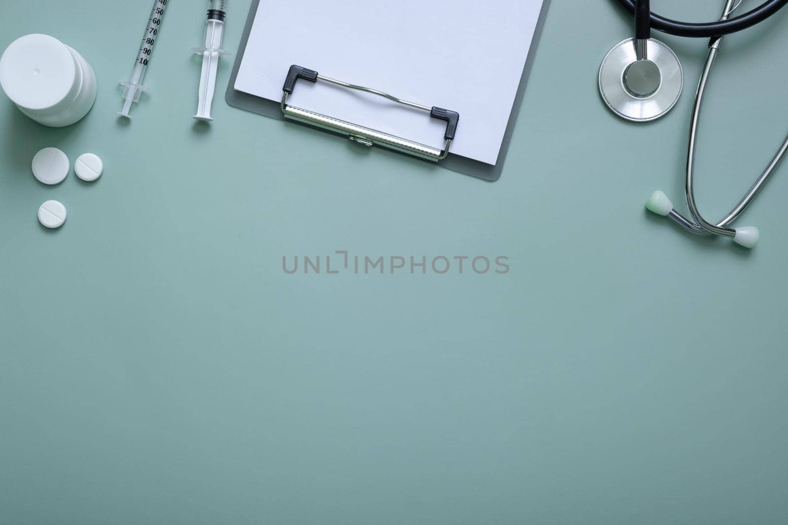 Stethoscope, syringes, pills and tablet at doctor's workplace on colored background top view. Medical flat lat with copy space.