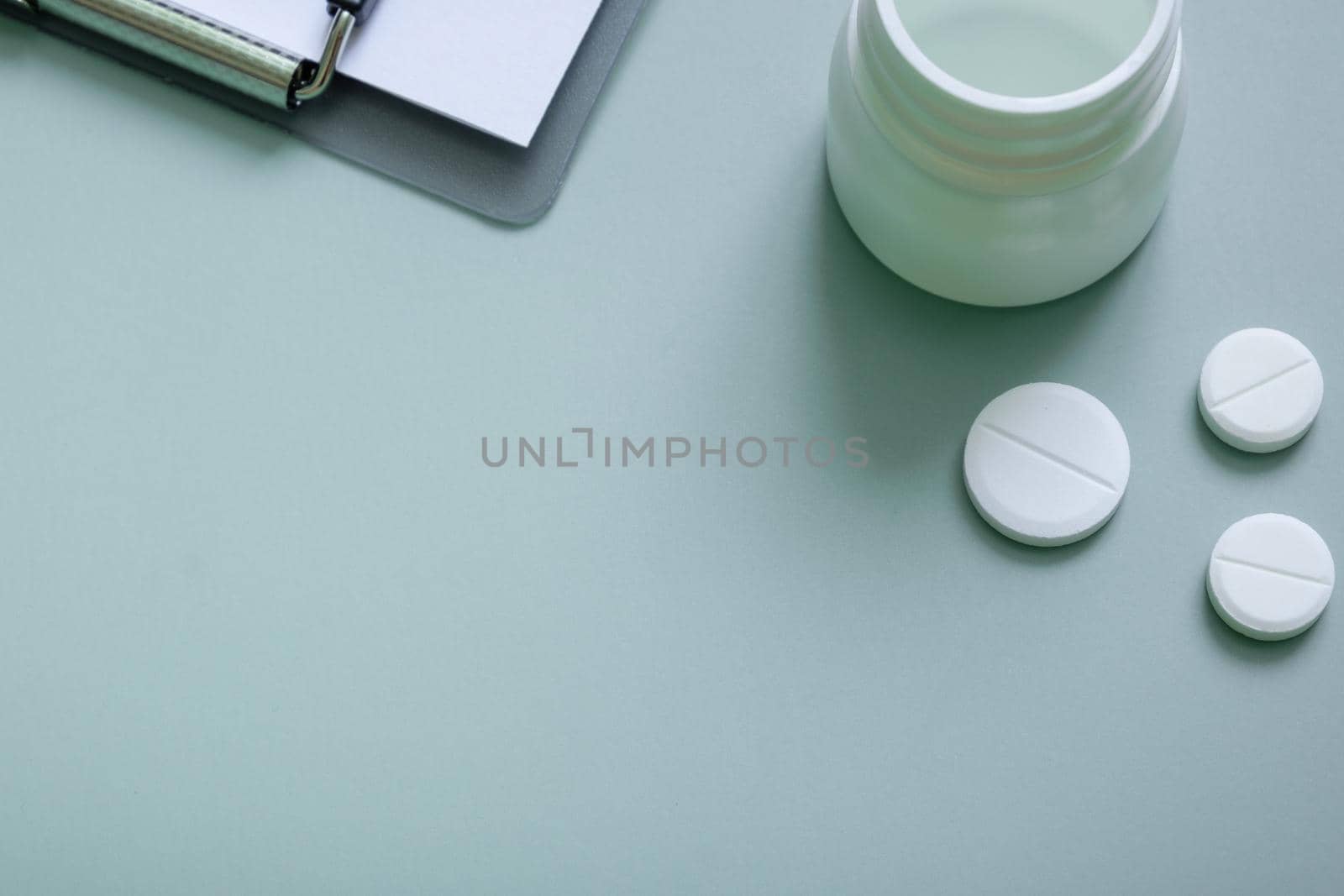 Pills and a tablet on colored background. Medical backdrop with copy space.