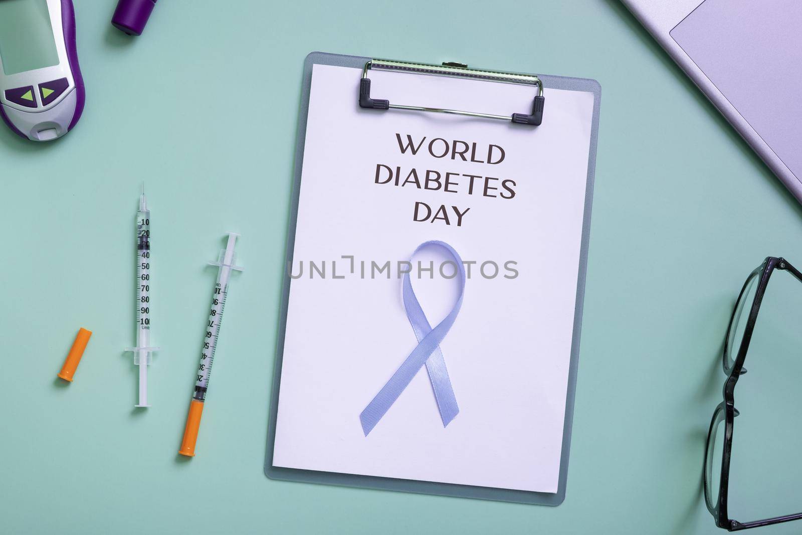 World Diabetes Day text with blue ribbon and glucometer, medical supplies on color background top view.