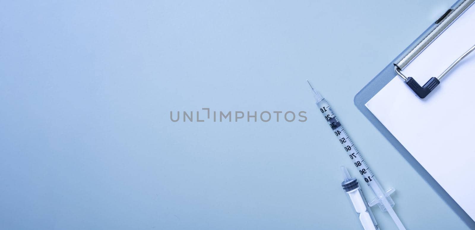 Banner with syringes and a tablet on colored background. Medical backdrop with copy space.