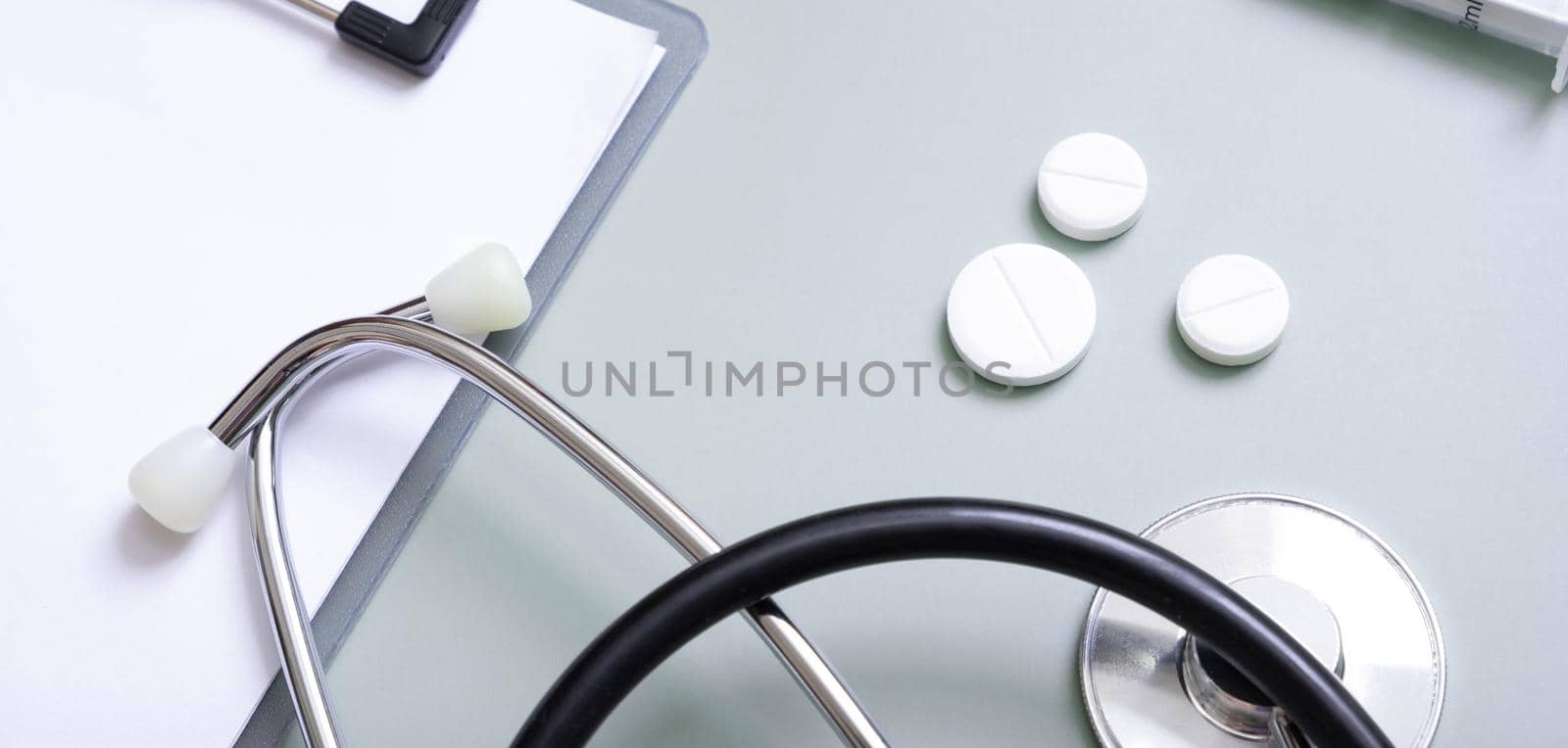 Banner with stethoscope, pills and tablet at doctor's workplace on colored background top view.