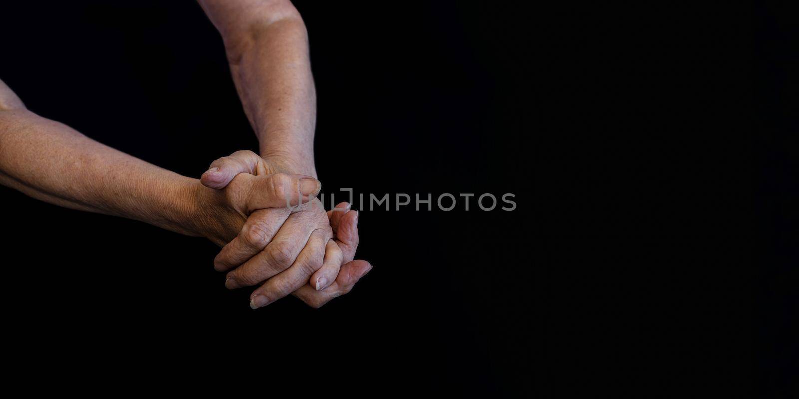 close-up, the hands of an old woman in wrinkles on a black background copy paste by Ramanouskaya