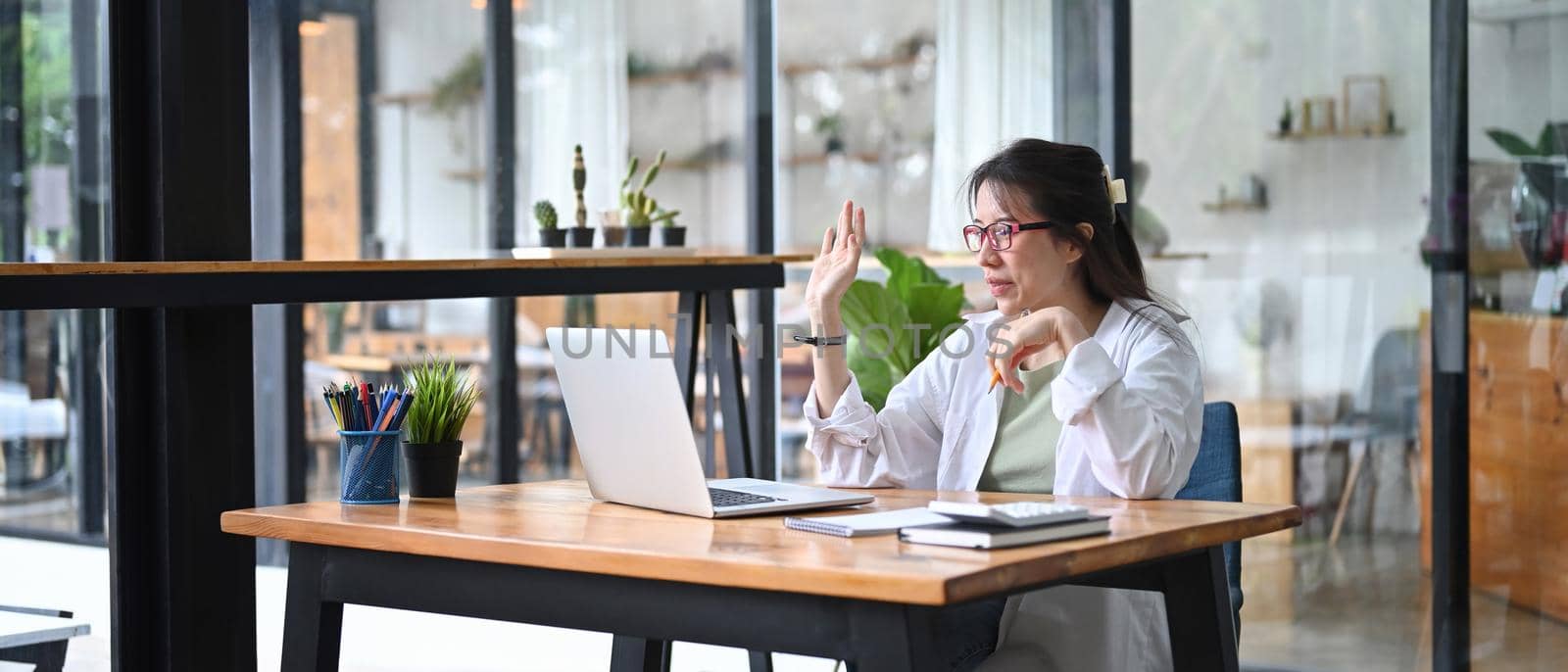 Smiling female small business entrepreneur having video conference on laptop computer.