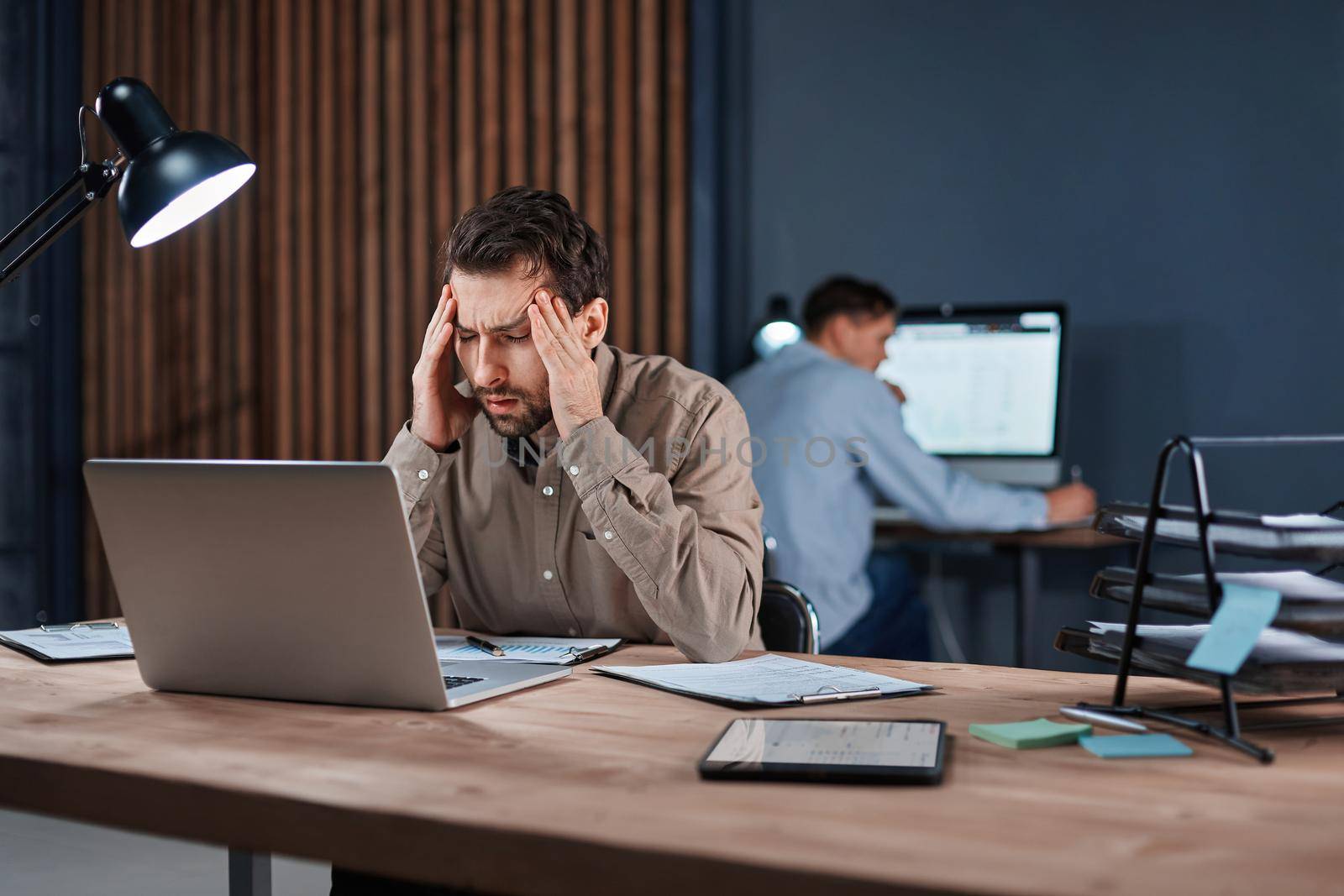 tired businessman working late at night on a new project . by SmartPhotoLab