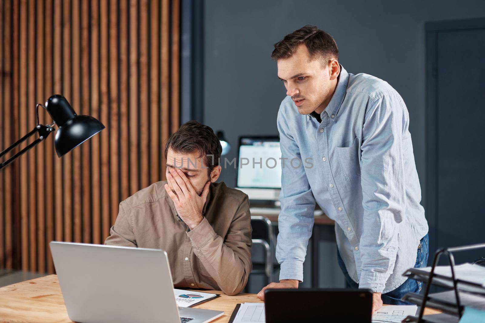 tired colleagues working with financial documents at night. by SmartPhotoLab